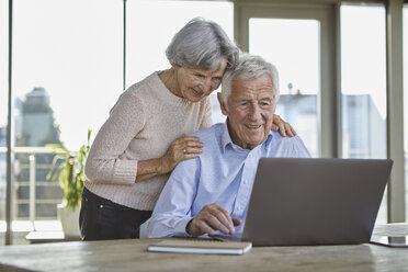 Portrait of smiling senior couple using laptop - RBF07006