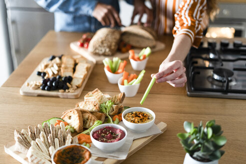 Ehepaar bereitet ein Abendessen vor, garniert Dips mit der Hand - ERRF00532