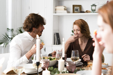 Friends having fun at a dinner party, enjoying eating together - ERRF00563