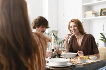 Friends having fun at a dinner party, enjoying eating together - ERRF00564