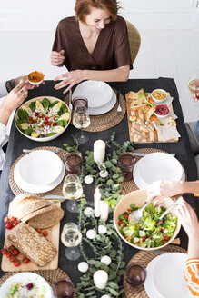 Freunde sitzen am gedeckten Tisch und genießen ihre Dinnerparty, Blick von oben - ERRF00569