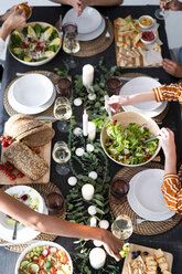 Friends sitting at laid table, enjoying their dinner party, view from above - ERRF00570