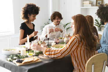 Friends having fun at a dinner party, enjoying eating together - ERRF00572