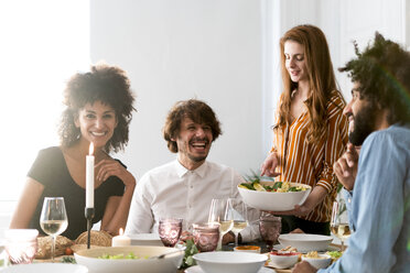 Friends having fun at a dinner party, enjoying eating together - ERRF00575