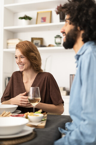 Freunde, die sich bei einer Dinnerparty amüsieren und das gemeinsame Essen genießen, lizenzfreies Stockfoto