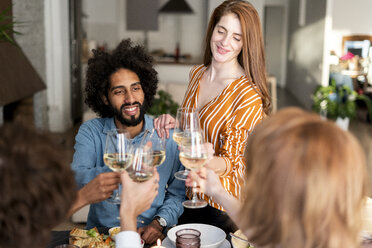 Friends drinking wine at a dinner party, clinking glasses - ERRF00582