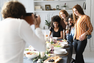 Freunde machen ein Gruppenfoto als Erinnerung an eine Dinnerparty - ERRF00584