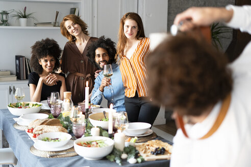 Freunde machen ein Gruppenfoto als Erinnerung an eine Dinnerparty - ERRF00585
