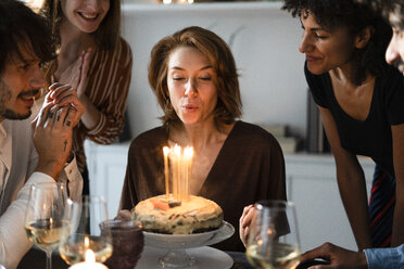 Freunde feiern den Geburtstag einer jungen Frau und blasen die Kerzen aus - ERRF00600