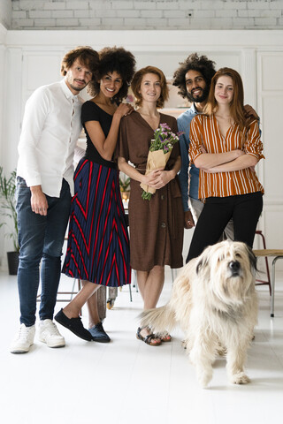 Gruppenbild mit einem Hund, von Freunden, die den Geburtstag einer jungen Frau feiern, lizenzfreies Stockfoto