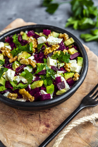 Schale mit Rote-Bete-Salat mit Avocado, Feta, Walnüssen und Petersilie, lizenzfreies Stockfoto