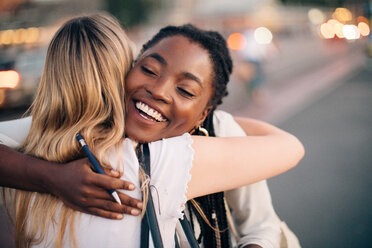 Multi-ethnic female friends embracing each other on street in city - MASF10298