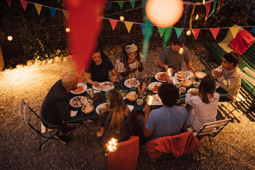 Blick von oben auf multiethnische Freunde beim Abendessen während einer Gartenparty im Hinterhof - MASF10436