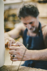 Älterer Handwerker beim Nähen von Möbeln in der Werkstatt - MASF10641