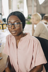 Portrait of confident young businesswoman sitting on chair in creative office - MASF10664