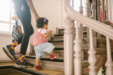Kleines Mädchen hält die Hand des Vaters beim Treppensteigen in der Wohnung - MASF10761