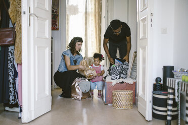 Tochter sieht Mutter und Vater beim Kofferpacken zu Hause zu - MASF10789