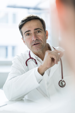 Portrait of doctor talking to patient in medical practice stock photo