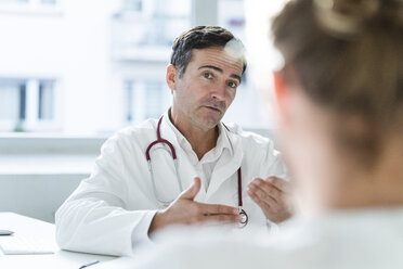 Porträt eines Arztes im Gespräch mit einem Patienten in einer Arztpraxis - JOSF02784