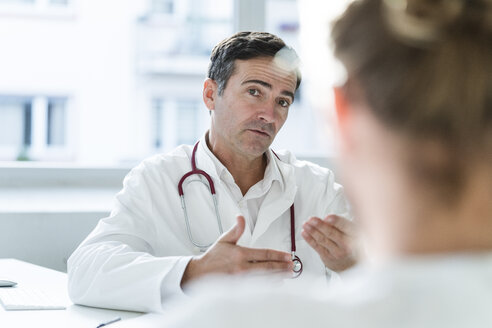 Porträt eines Arztes im Gespräch mit einem Patienten in einer Arztpraxis - JOSF02784