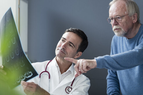 Doctor discussing MRT image with senior patient in medical practice - JOSF02785