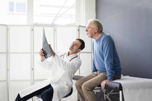 Doctor discussing MRT image with patient in medical practice - JOSF02812