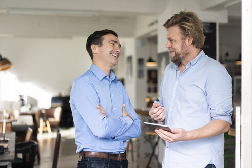 Two happy businessmen with tablet talking - JOSF02848