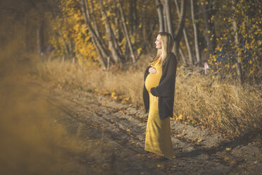 Schwangere Frau auf einem Waldweg im Herbst - ASCF00939