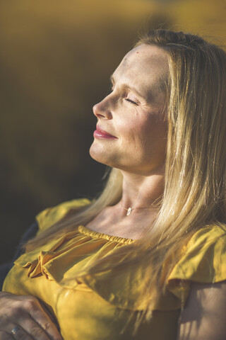 Smiling woman with closed eyes enjoying the sunshine stock photo