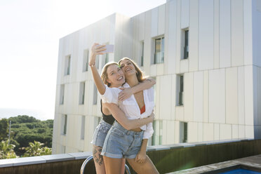 Girlfriends on a rooftop terrace, having fun by the pool, taking selfies - VABF02106