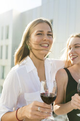 Freundinnen auf einer Dachterrasse, die sich am Pool vergnügen und Rotwein trinken - VABF02111