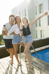 Friends having fun at a rooftop pool, drinking red wine - VABF02112