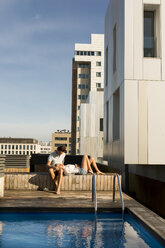 Pärchen entspannt sich auf der Dachterrasse am Pool - VABF02117