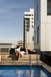 Pärchen entspannt sich auf der Dachterrasse am Pool - VABF02118