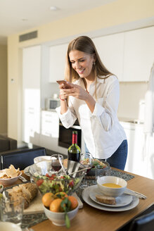 Frau, die den gedeckten Tisch für ein Mittagessen mit Freunden fotografiert - VABF02125