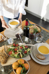 Junge Frau bereitet den Tisch für das Mittagessen mit Freunden vor - VABF02126