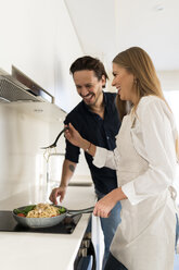 Happy couple preparing spaghetti in their kitchen - VABF02128
