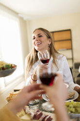 Junge Frau trinkt Rotwein bei einem Mittagessen mit Freunden - VABF02141