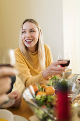 Junge Frau trinkt Rotwein bei einem Mittagessen mit Freunden - VABF02152