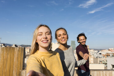 Friends having fun on an urban rooftop terrace, holding hands - VABF02203