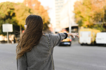 Young woman commuting in the city, hailing a taxi - ERRF00631