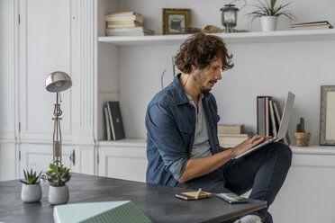 Mann bei der Arbeit im Coworking Space, mit Laptop - AFVF02221