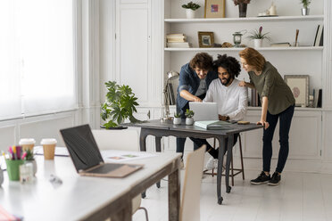 Junge Kreativschaffende arbeiten gemeinsam in einem Coworking Space - AFVF02230