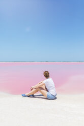 Mexiko, Yucatan, Las Coloradas, Salzsee Pink Lake, Frau sitzt am Strand - MMAF00750