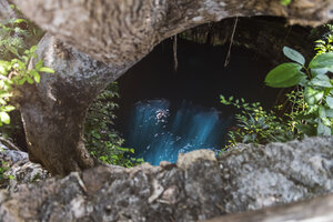 Mexiko, Yucatan, Mann schwimmt in einer Cenote - MMAF00759