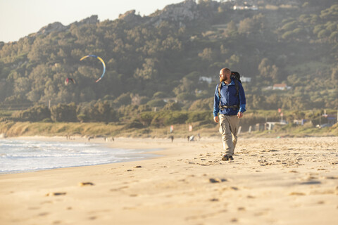 Spanien, Andalusien, Tarifa, Mann beim Wandern am Strand, lizenzfreies Stockfoto