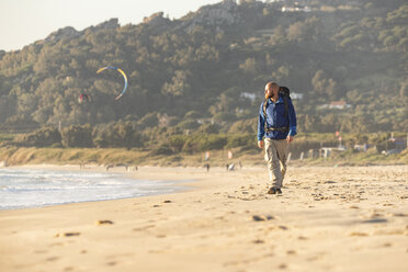 Spanien, Andalusien, Tarifa, Mann beim Wandern am Strand - KBF00401