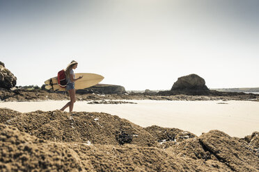 Junge Frau am Strand, mit Surfbrett, mit Smartphone - UUF16428