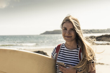 Junge Frau am Strand, mit Surfbrett - UUF16439