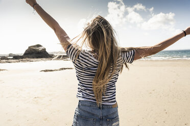 Happy young woman dancing on the beach - UUF16444